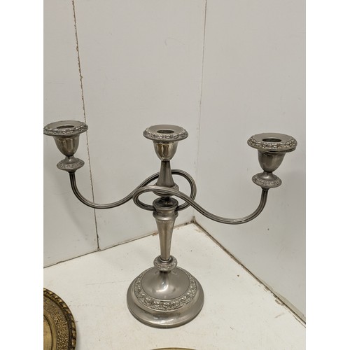 876 - A Pair of silver plated candle sticks, and a selection of brass plates