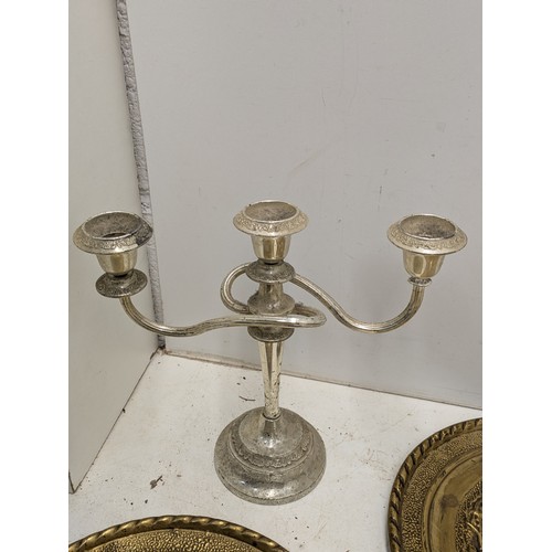 876 - A Pair of silver plated candle sticks, and a selection of brass plates