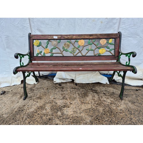 215 - A garden bench with floral effects cast iron back and ends