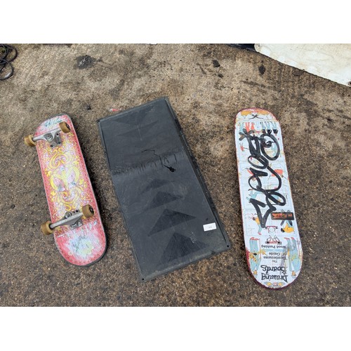 219 - A pair of skateboards and a plastic skate ramp