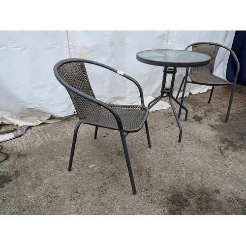 8 - A steel and glass topped bistro table with wicker seat bases