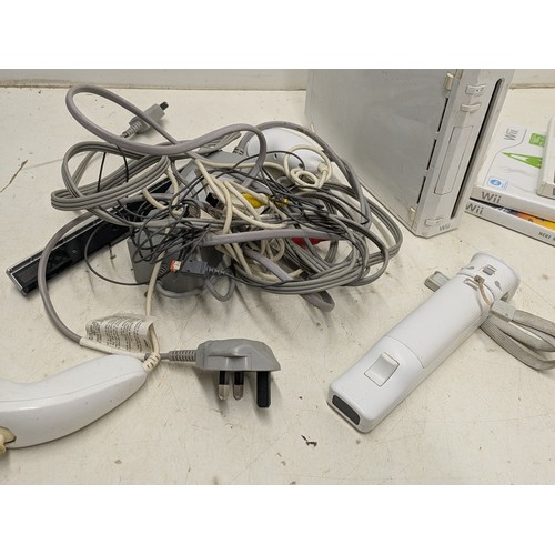 1219 - A Nintendo Wii console with cables, controllers and a selection of games