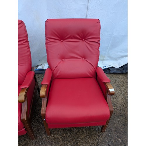 421 - A pair of retro style reclining armchairs with a pine frame and red vinyl upholstery