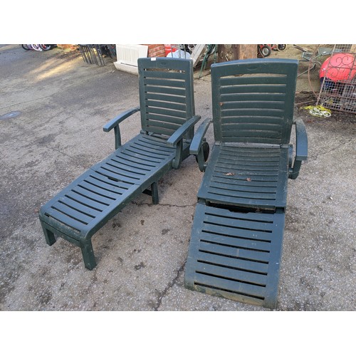 65 - A pair of green plastic sun loungers