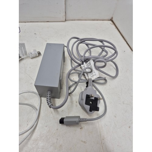 1402 - A Nintendo Wii console with cables and controller