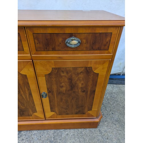 613 - A walnut verniered storage cabinet with three drawer and three storage spaces underneath.