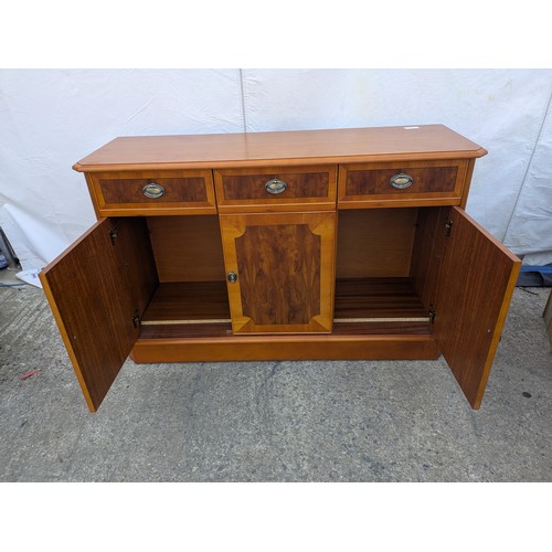 613 - A walnut verniered storage cabinet with three drawer and three storage spaces underneath.