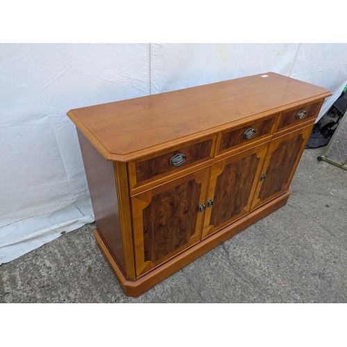 613 - A walnut verniered storage cabinet with three drawer and three storage spaces underneath.