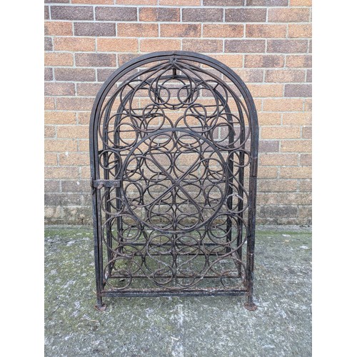 643 - An antique 23 bottle wrought iron wine rack, with latching door and charming detail