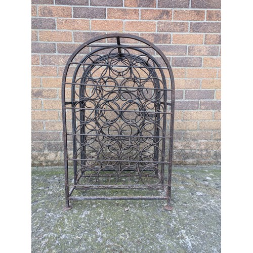 643 - An antique 23 bottle wrought iron wine rack, with latching door and charming detail