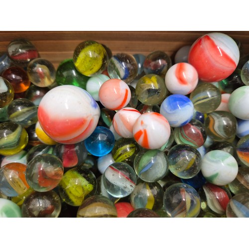 1017 - A large job lot of marbles in a retro wooden box/carry case