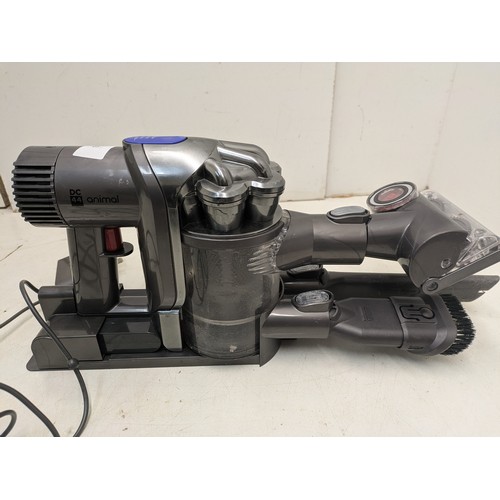 1483 - A Dyson DC04 cordless vacuum with charger and attachments - powers  on