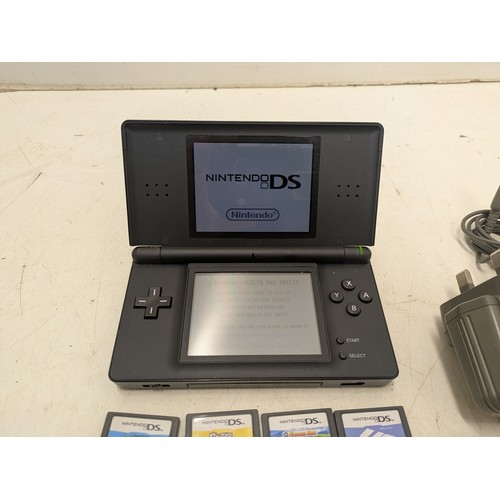 1495 - A Nintendo DS Lite black console and 4 games - powers on