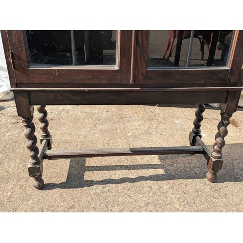 657 - A traditional 2 door oak display cabinet with leaded and stained glass doors