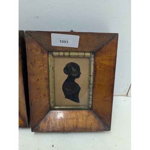 1093 - A pair of early 20th century silhouettes in walnut veneer frames