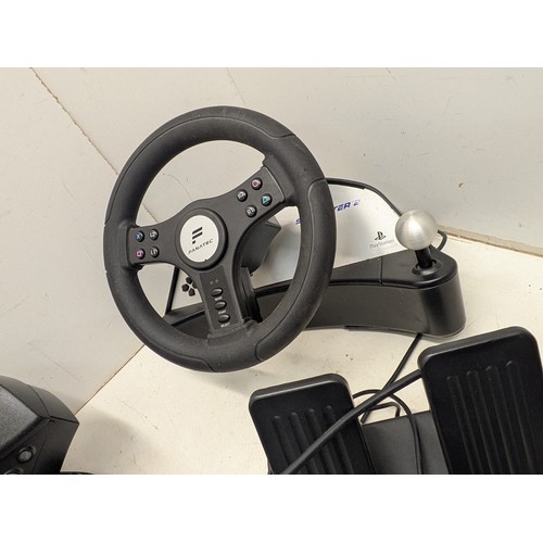 1512 - A selection of racing steering wheels and pedals for use with various video game consoles