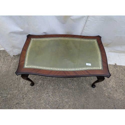 511 - A stylish mahogany verniered glass and leather topped coffee table