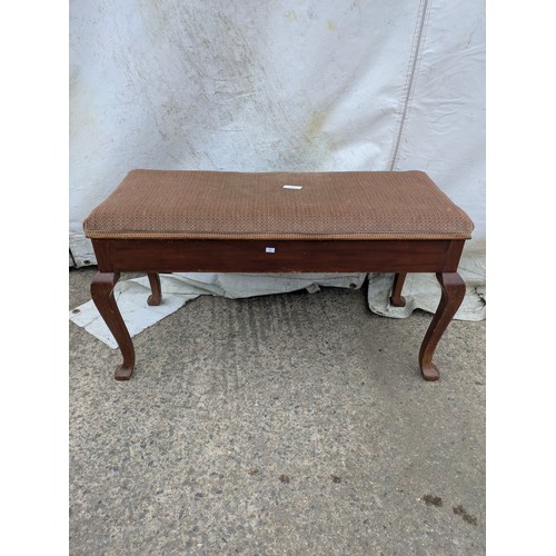 463 - A vintage piano stool with a seated fabric base and internal storage