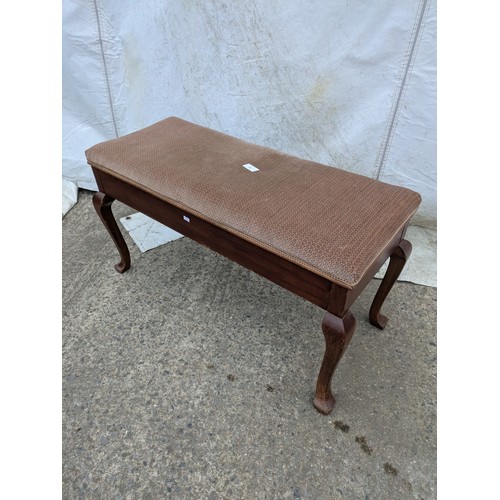 463 - A vintage piano stool with a seated fabric base and internal storage