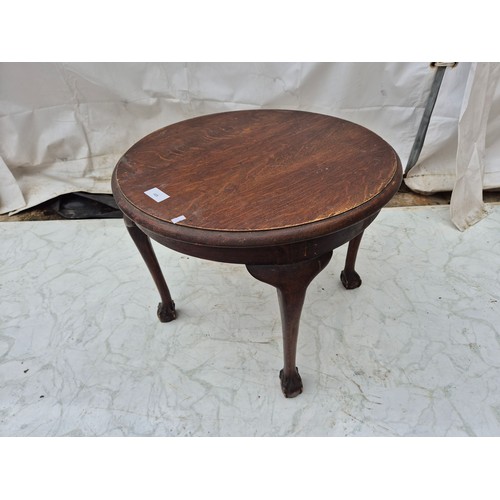 459 - An early 20th century oak circular table with lions paw fer