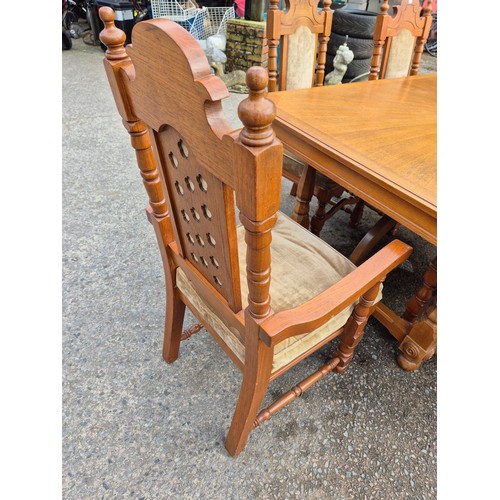 413 - A large oak dining table with 6 dining chairs - nicely carved with a cream fabric padded upholstery