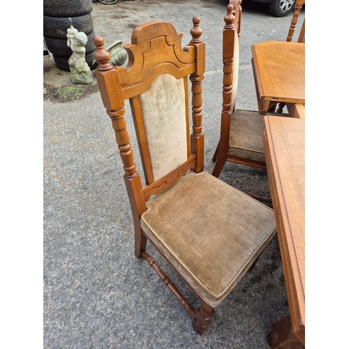 413 - A large oak dining table with 6 dining chairs - nicely carved with a cream fabric padded upholstery