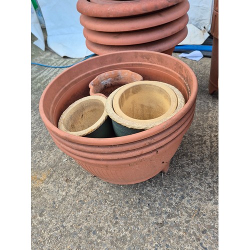 21 - A large selection of plastic and terracotta plant pots