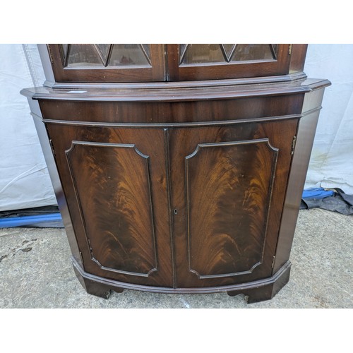 614 - A mahogany veneered corner display glass fronted cabinet.