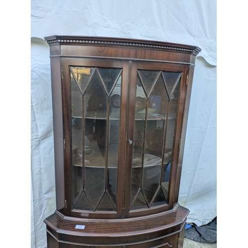 614 - A mahogany veneered corner display glass fronted cabinet.