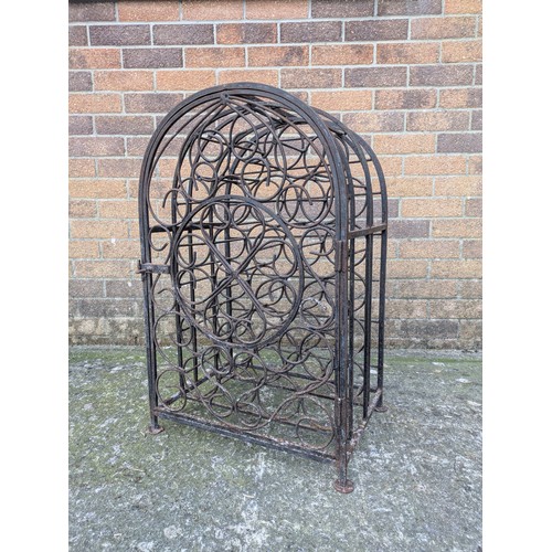 643 - An antique 23 bottle wrought iron wine rack, with latching door and charming detail