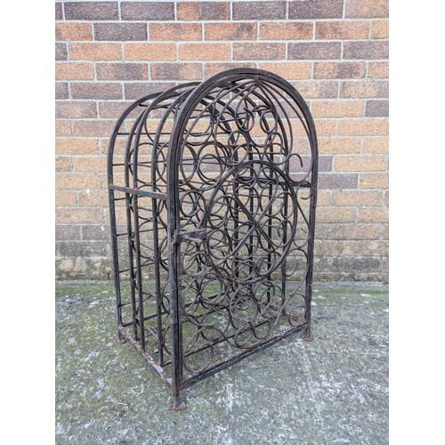 643 - An antique 23 bottle wrought iron wine rack, with latching door and charming detail