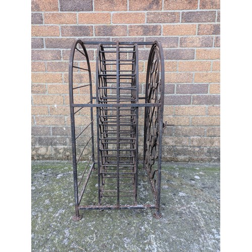 643 - An antique 23 bottle wrought iron wine rack, with latching door and charming detail