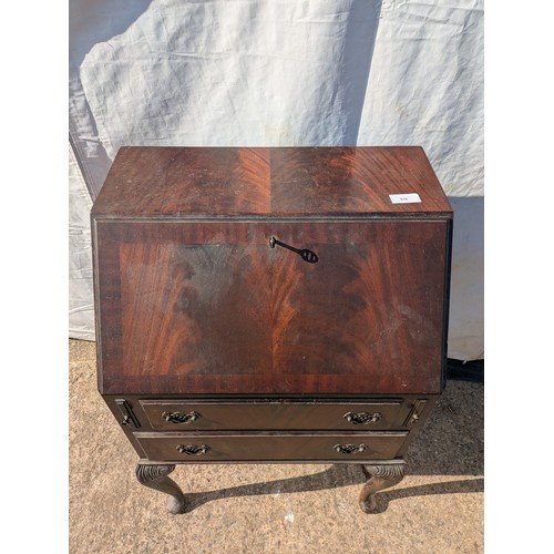 656 - An antique mahogany bureau with ornate carved legs, underlying drawers and interior compartments