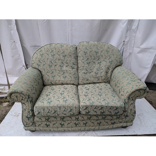 644 - A 2 seater green floral fabric sofa