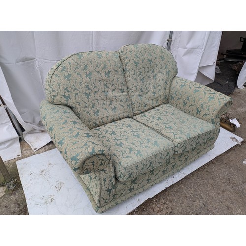 644 - A 2 seater green floral fabric sofa