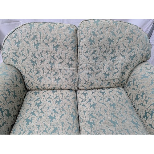 644 - A 2 seater green floral fabric sofa