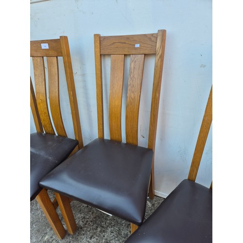 27 - 4x Oak dining chairs, with brown padded vinyl seat bases.