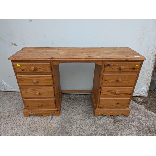 654 - A pine desk with 8 drawers