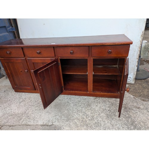 694 - A pine side unit with 4 drawers and 2 cupboard spaces