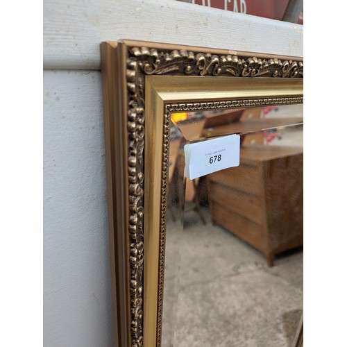 678 - A bevelled edge dressing mirror in am ornate gold gilt floral carved frame