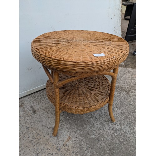 687 - A wicker circular side table with underlying shelf