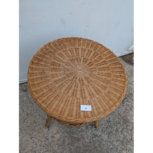 687 - A wicker circular side table with underlying shelf