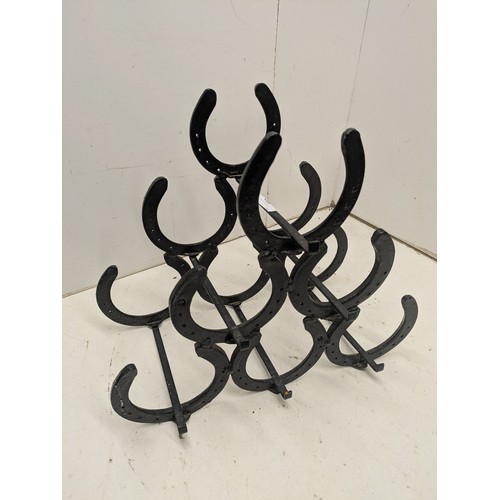 692 - A 6 bottle horseshoe wine bottle rack