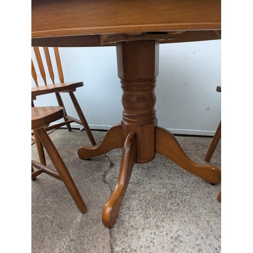 647 - An oak circle dining table with 4 matching dining chairs