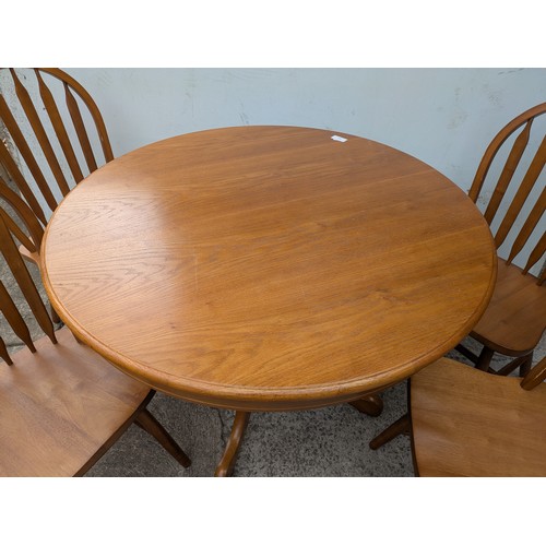 647 - An oak circle dining table with 4 matching dining chairs