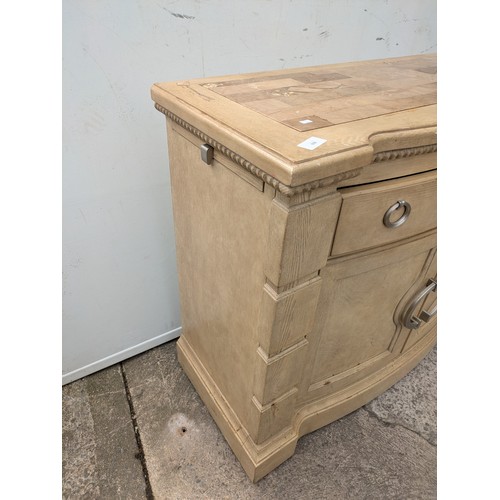 659 - A modern oak storage unit with a marble chess board style top, with drawer and cupboard space