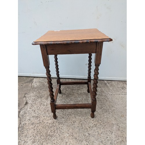 672 - A vintage oak side table with barley twist legs