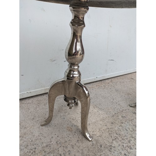 433 - A pair of polished aluminium side tables with tripod bases