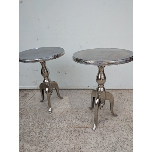 433 - A pair of polished aluminium side tables with tripod bases