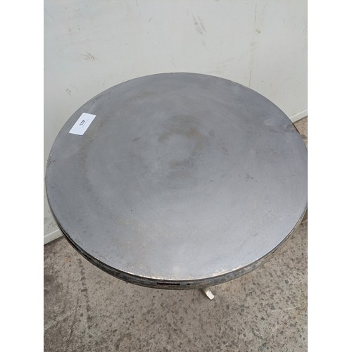433 - A pair of polished aluminium side tables with tripod bases